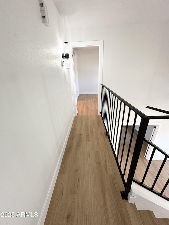 hallway with baseboards and wood finished floors