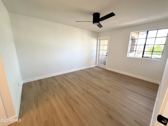 unfurnished room featuring baseboards, plenty of natural light, a ceiling fan, and wood finished floors