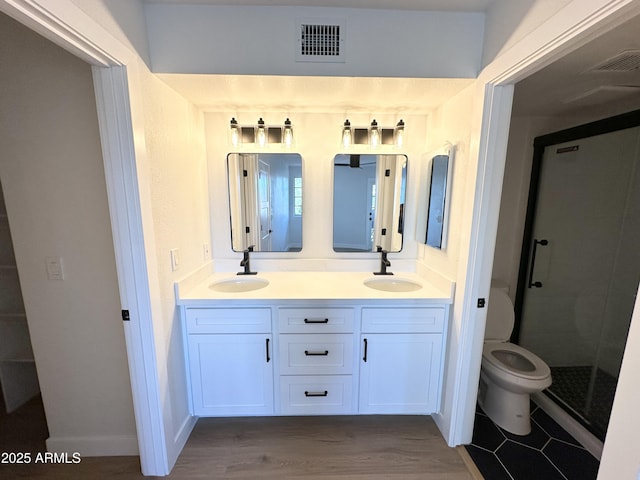 full bathroom with visible vents, a sink, a stall shower, and double vanity