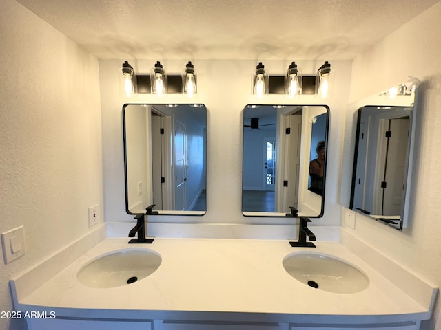 bathroom with a sink, a textured ceiling, and a textured wall