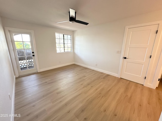 empty room with a ceiling fan, baseboards, and light wood-style flooring