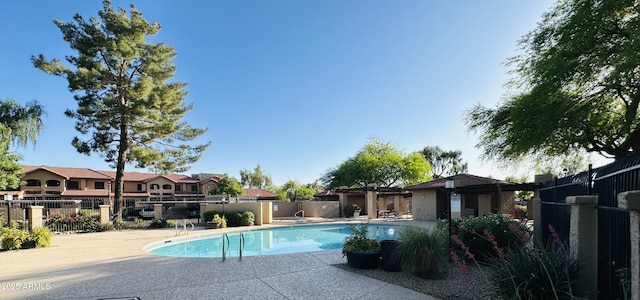 pool featuring fence, a residential view, and a patio area