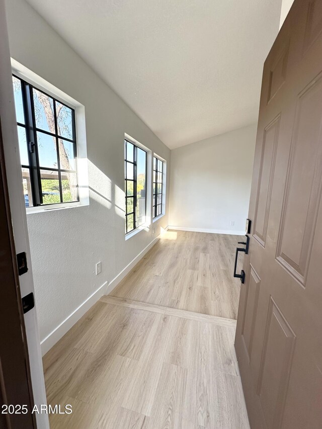 unfurnished room featuring baseboards and light wood-style floors