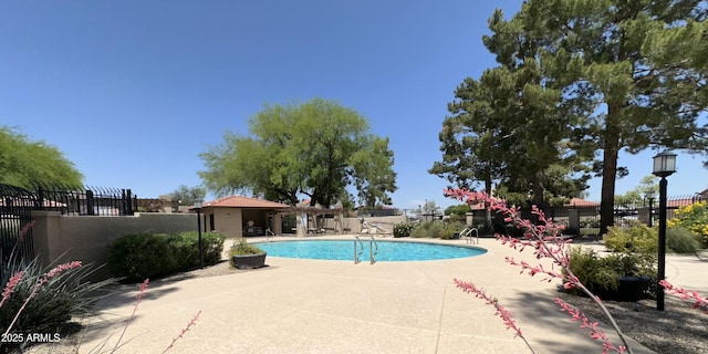 pool featuring fence and a patio