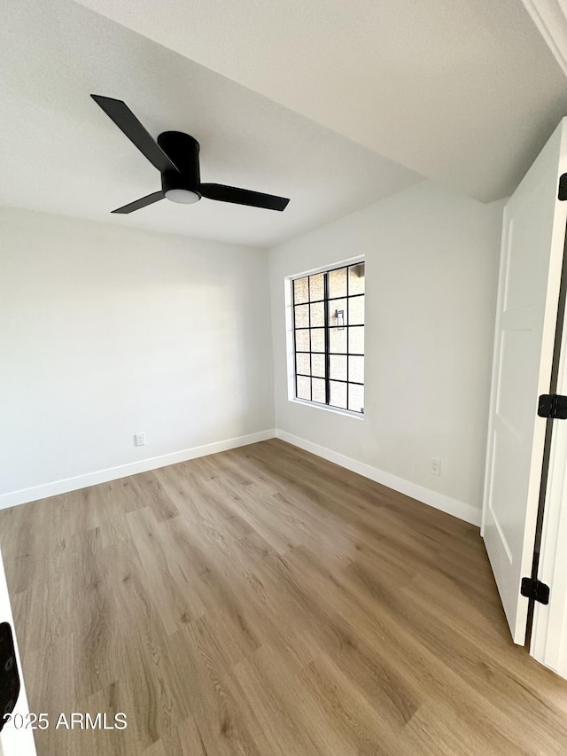 unfurnished room with baseboards, a ceiling fan, and wood finished floors