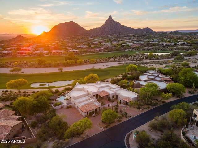 aerial view at dusk featuring a residential view, golf course view, and a mountain view