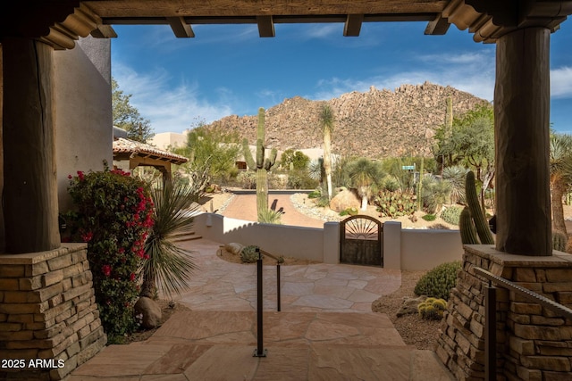 view of patio / terrace with fence, a gate, and a mountain view