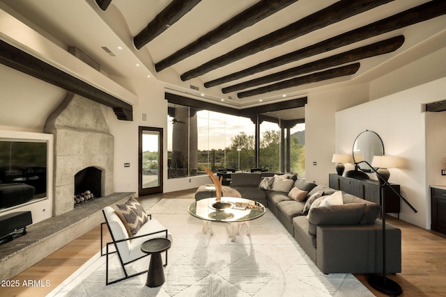 living area featuring recessed lighting, wood finished floors, visible vents, beam ceiling, and a tiled fireplace