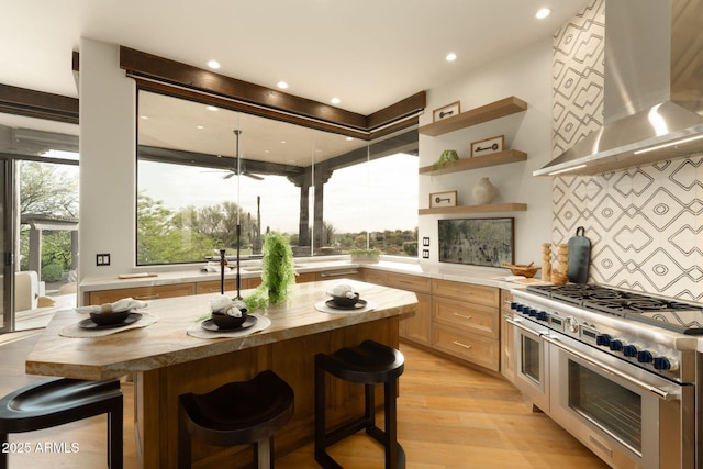 kitchen with tasteful backsplash, butcher block countertops, double oven range, and extractor fan