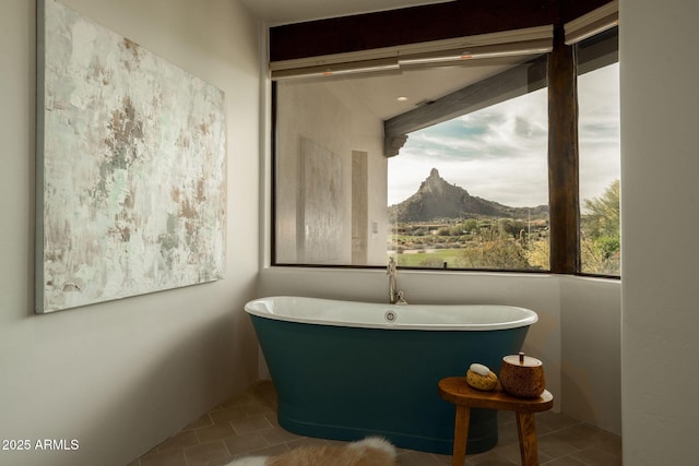 bathroom with tile patterned flooring, a freestanding bath, and a mountain view
