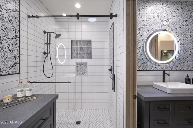 bathroom featuring tile walls, vanity, and a shower stall