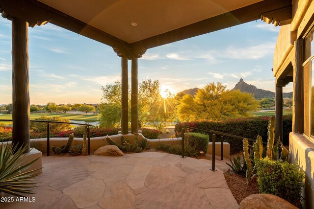 view of patio with a mountain view and golf course view