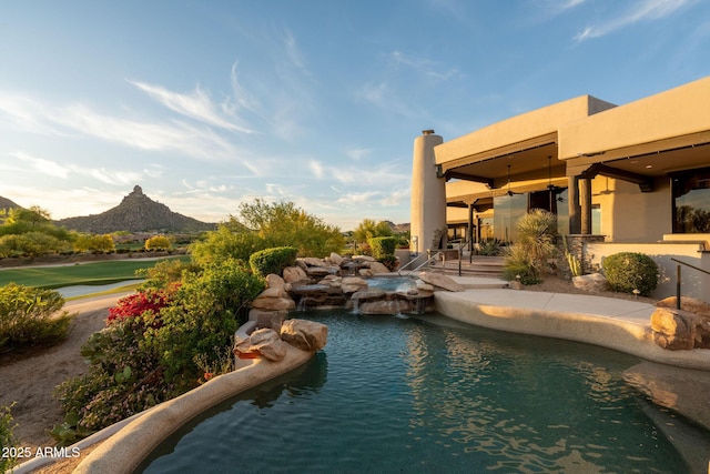 view of pool with a mountain view, a patio area, and a pool with connected hot tub