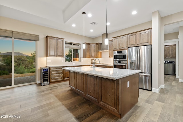 kitchen featuring wine cooler, light wood finished floors, visible vents, appliances with stainless steel finishes, and wall chimney exhaust hood