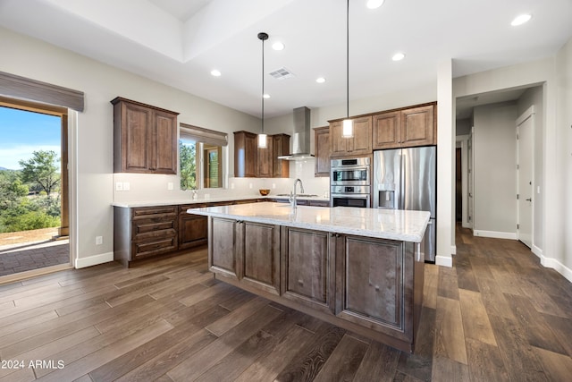 kitchen with appliances with stainless steel finishes, visible vents, wall chimney exhaust hood, and dark wood-style floors