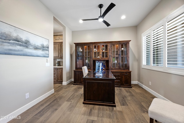 office space with baseboards, dark wood finished floors, and a ceiling fan