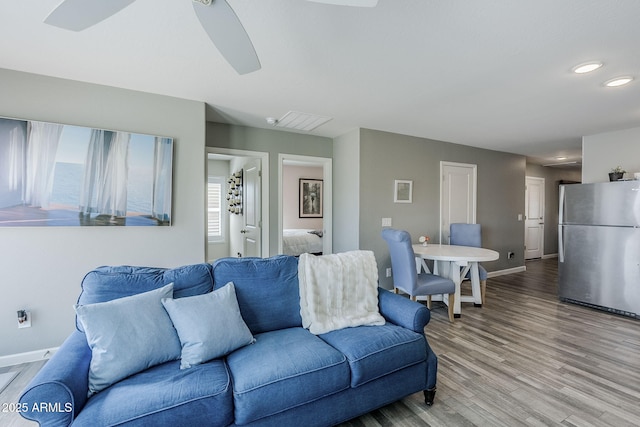 living area with light wood finished floors, recessed lighting, a ceiling fan, and baseboards