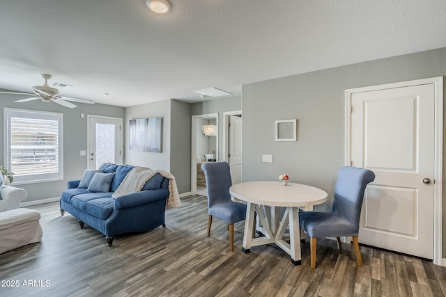 interior space featuring a textured ceiling, dark wood finished floors, visible vents, and baseboards