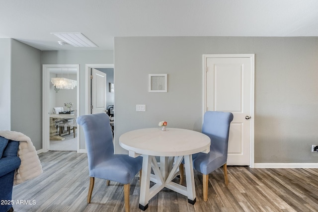 dining area with an inviting chandelier, baseboards, and wood finished floors