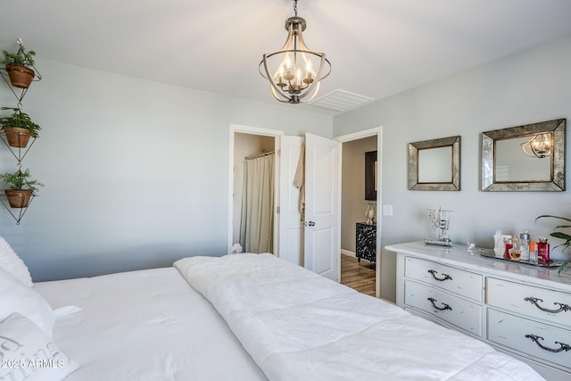 bedroom featuring a chandelier and dark wood finished floors