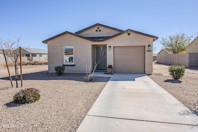 single story home featuring driveway, an attached garage, fence, and stucco siding