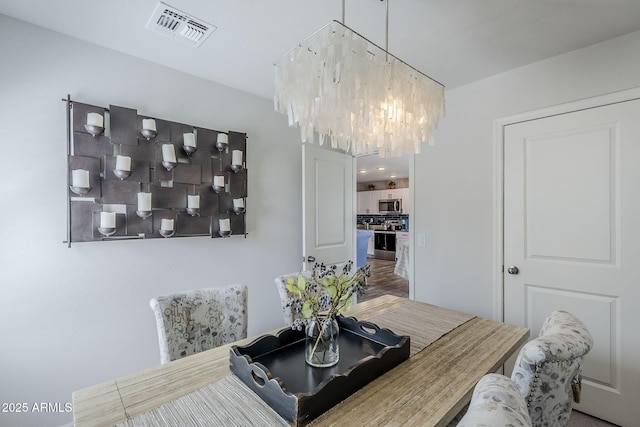 dining area featuring an inviting chandelier and visible vents