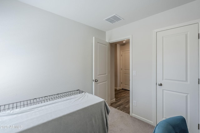 carpeted bedroom featuring baseboards and visible vents