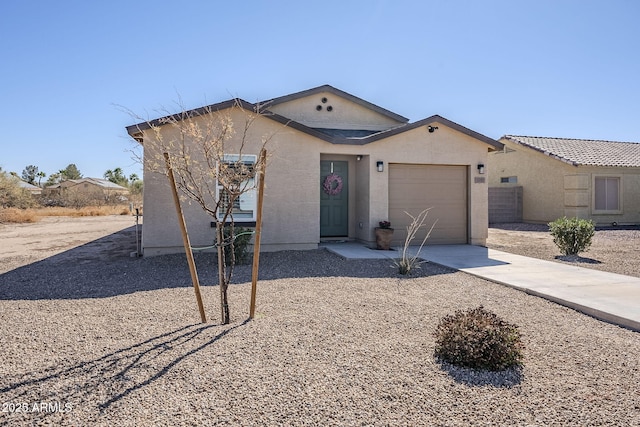 ranch-style home featuring driveway, an attached garage, and stucco siding