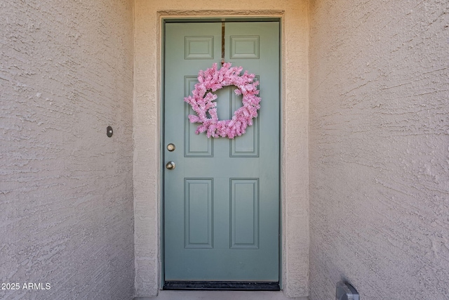 entrance to property with stucco siding