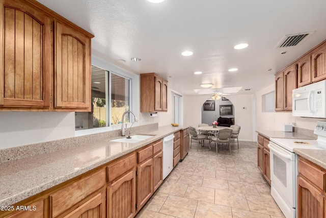 kitchen with ceiling fan, sink, white appliances, light stone countertops, and a textured ceiling