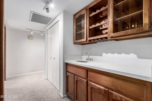 bar featuring sink and light colored carpet