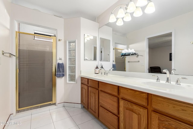 bathroom with a shower with shower door, vanity, and tile patterned floors