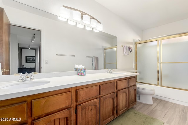 full bathroom with toilet, combined bath / shower with glass door, and vanity