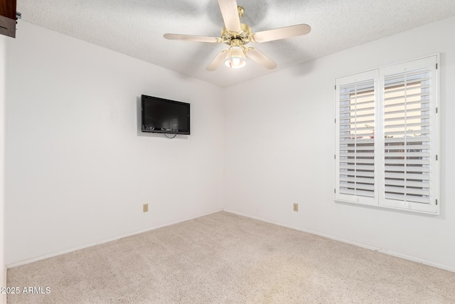 spare room featuring a textured ceiling, ceiling fan, and carpet