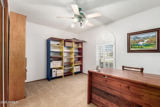 carpeted office featuring ceiling fan and a textured ceiling