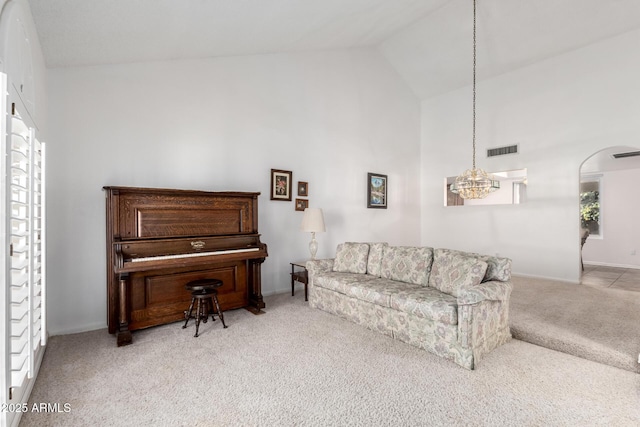 carpeted living room featuring high vaulted ceiling