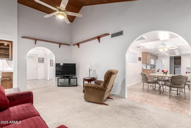 carpeted living room featuring high vaulted ceiling, wooden ceiling, and ceiling fan