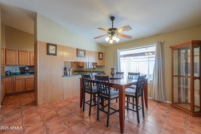 dining space with lofted ceiling, light tile patterned floors, and a ceiling fan