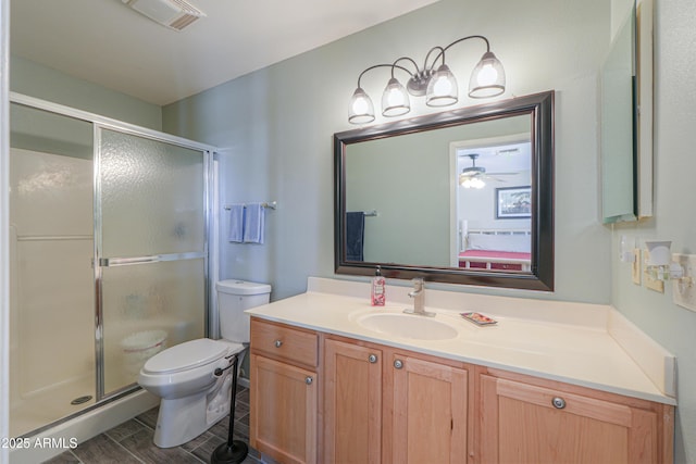 bathroom featuring toilet, visible vents, a shower stall, and vanity
