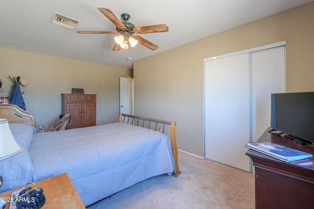 bedroom with carpet, visible vents, ceiling fan, and a closet