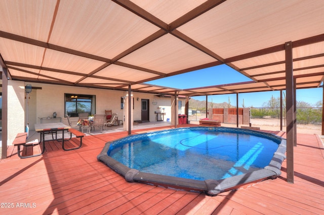 pool featuring fence, a deck, and outdoor dining area