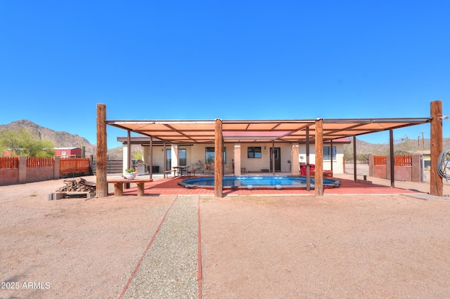 back of property featuring fence, a patio, a mountain view, and a fenced in pool