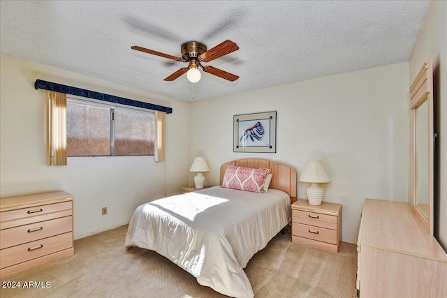 carpeted bedroom with ceiling fan and a textured ceiling