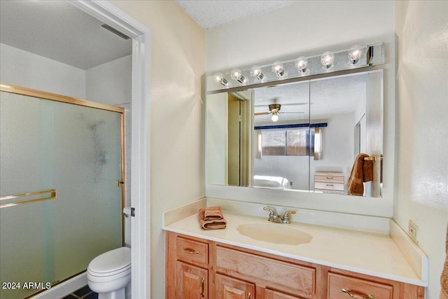 bathroom featuring a shower with door, vanity, a textured ceiling, and toilet