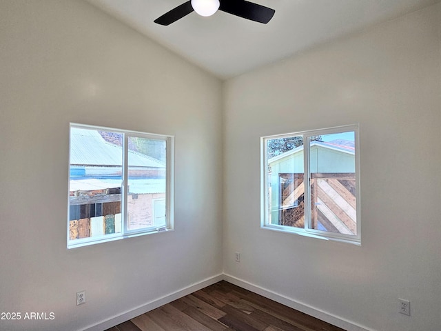 spare room with lofted ceiling, dark wood-style flooring, ceiling fan, and baseboards