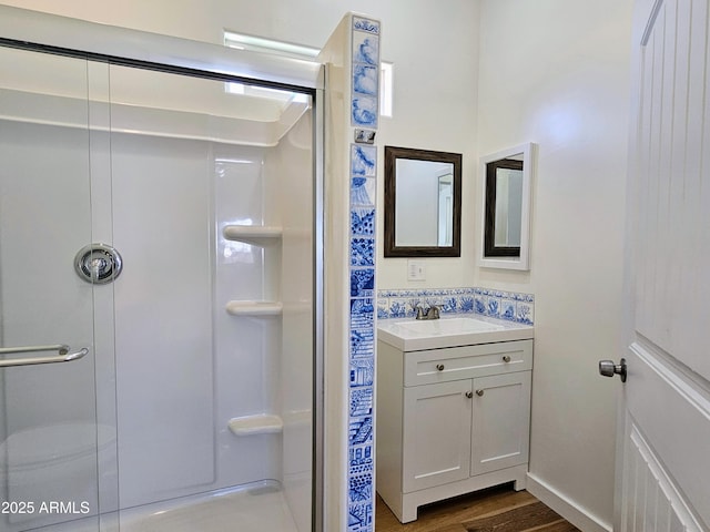 bathroom featuring a shower stall, wood finished floors, and vanity