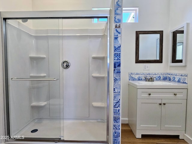 full bath featuring a stall shower, wood finished floors, and vanity