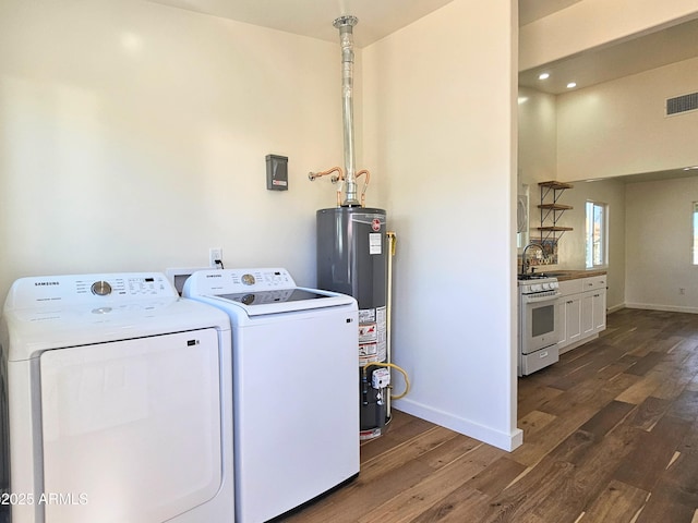 laundry room with laundry area, visible vents, dark wood-style flooring, independent washer and dryer, and gas water heater