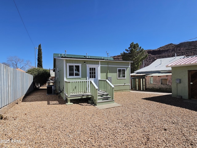 back of house with fence, a mountain view, and central air condition unit