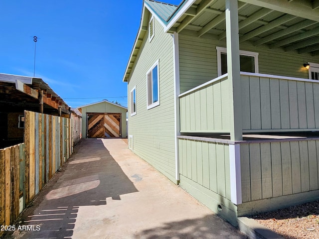 view of property exterior with an outbuilding, metal roof, and a storage unit